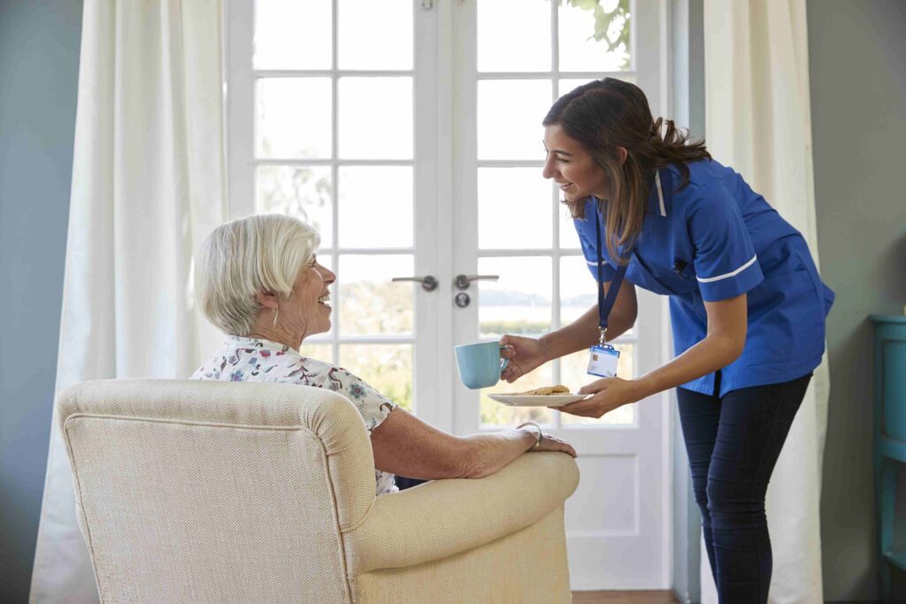 Caregiver providing home care services to elderly woman in Mumbai, demonstrating personal care and attention.